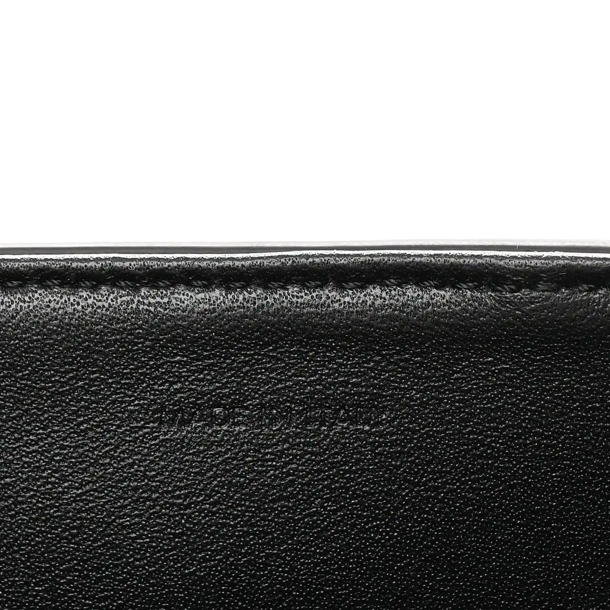 Black grained leather close-up with smooth edge seam detail