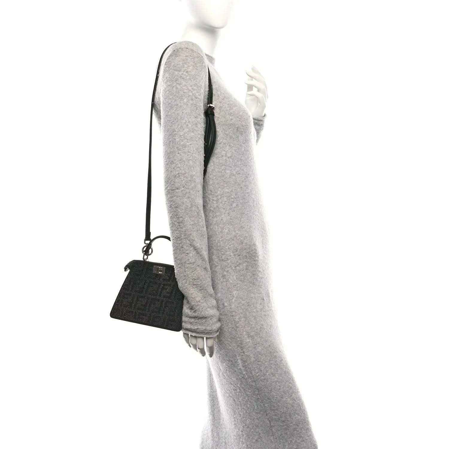 Black crystal satchel with adjustable shoulder strap, side view on model
