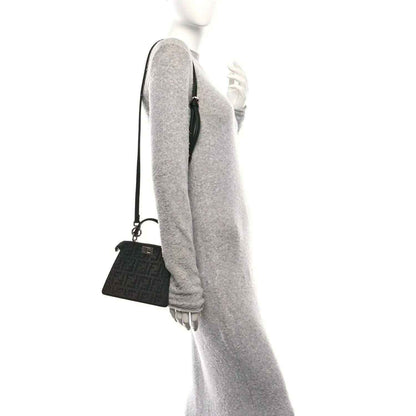 Black crystal satchel with adjustable shoulder strap, side view on model