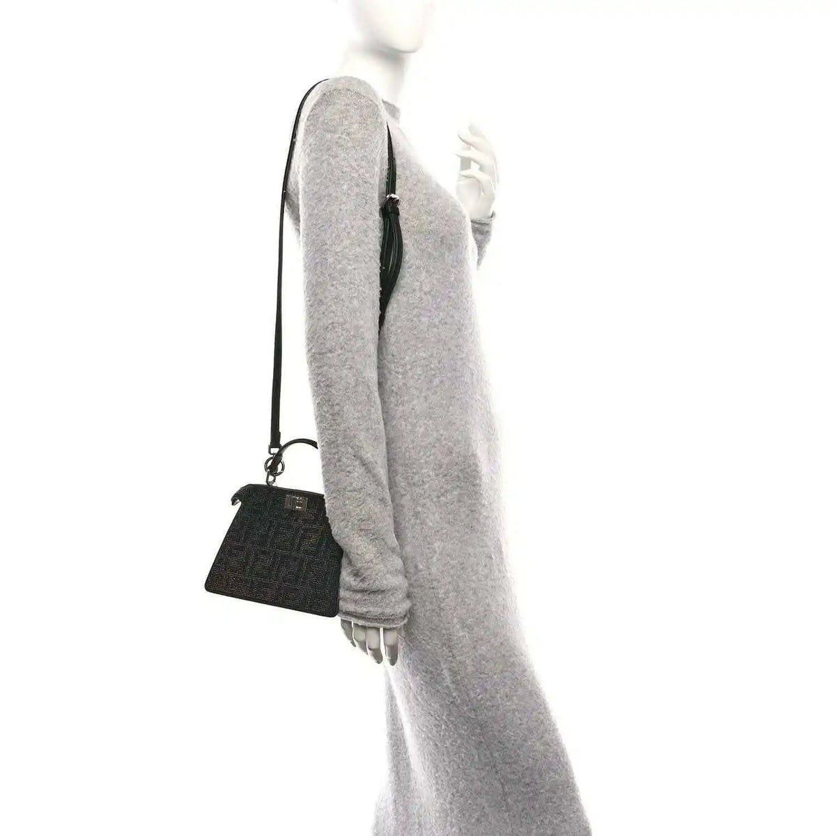Black crystal satchel with adjustable shoulder strap, side view on model