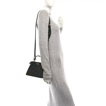 Black crystal satchel with adjustable shoulder strap, side view on model