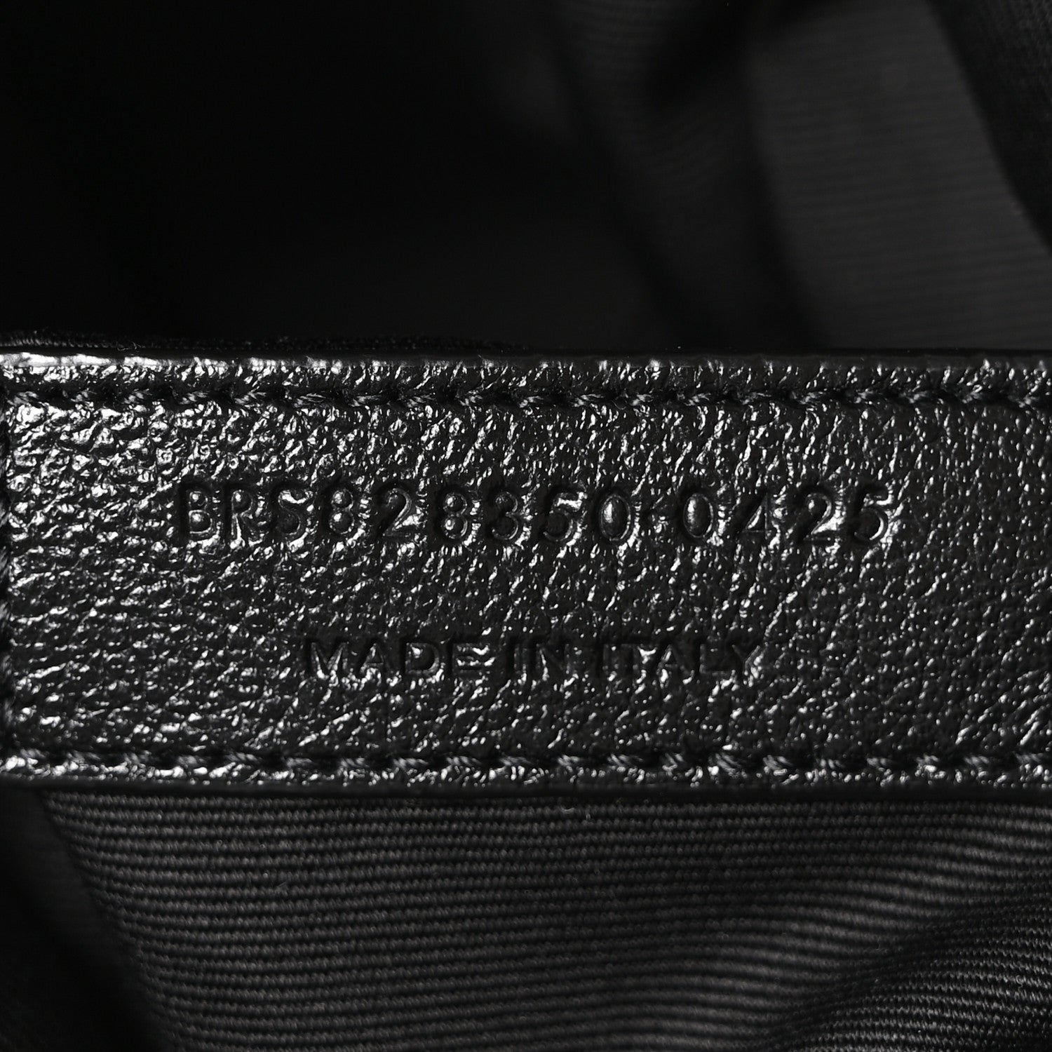 Embossed product code on black leather interior with stitched seam
