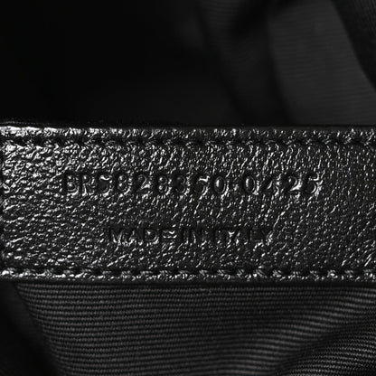Embossed product code on black leather interior with stitched seam