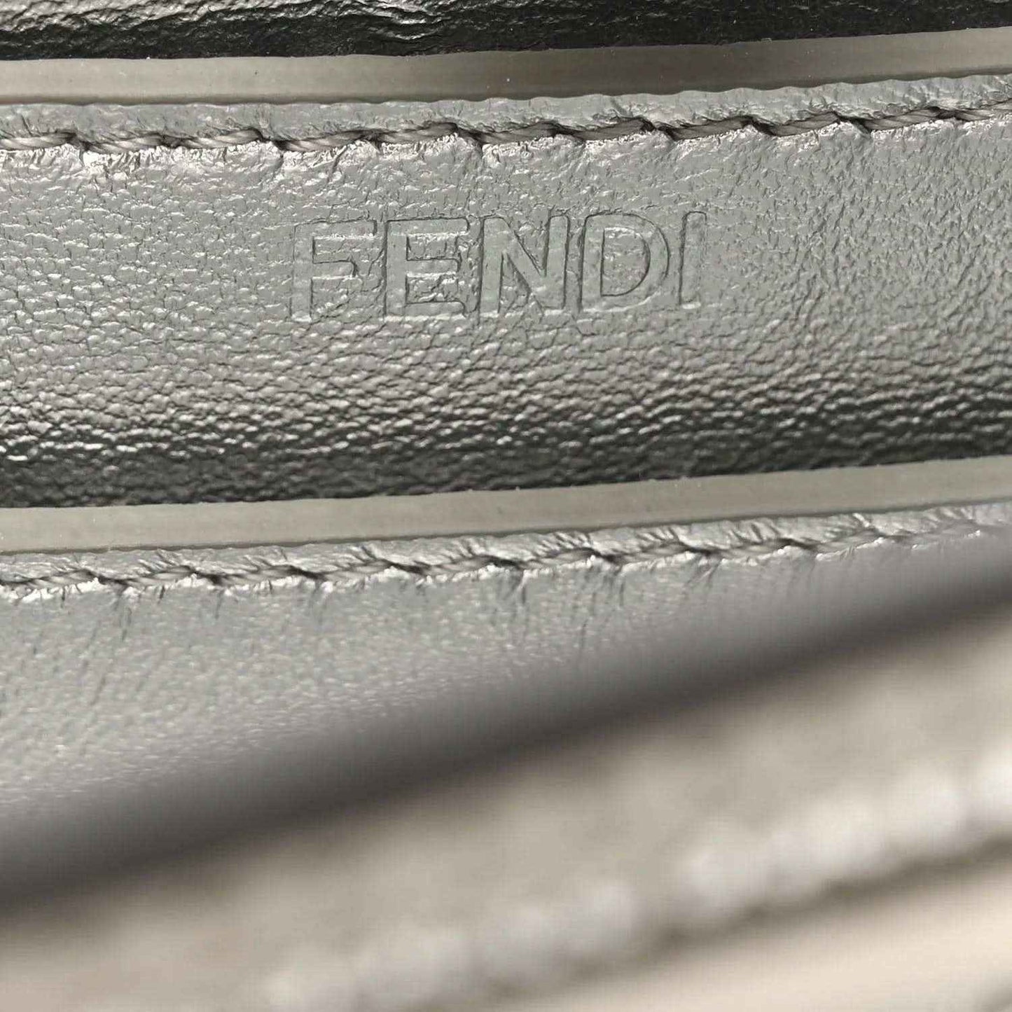 Embossed FENDI lettering on interior leather lining, with stitching detail.