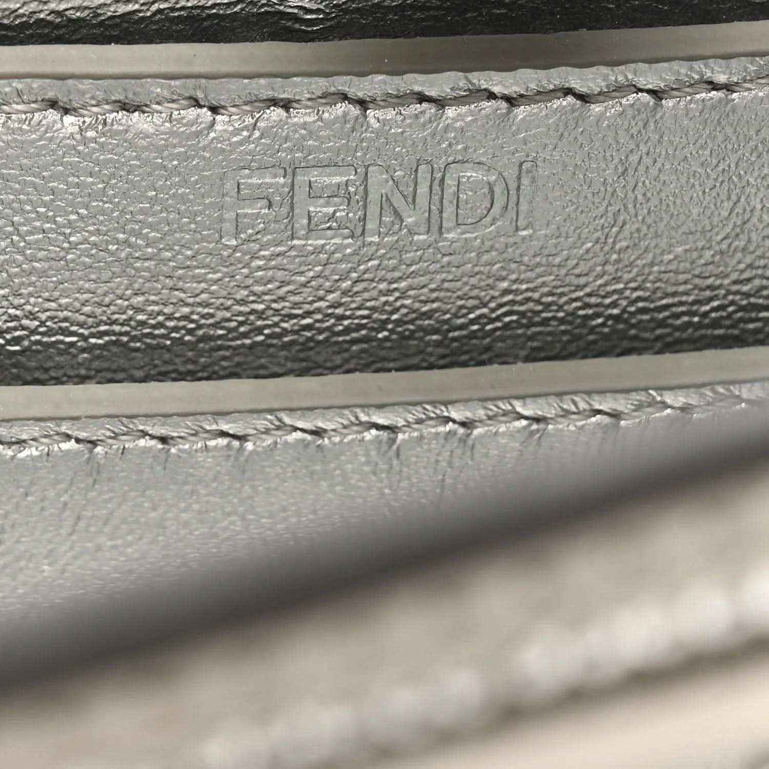 Embossed FENDI lettering on interior leather lining, with stitching detail.