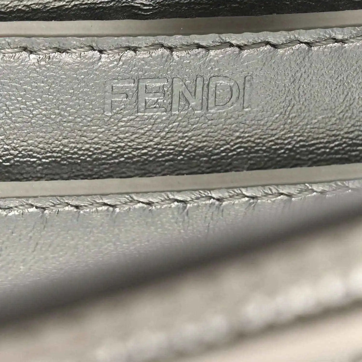 Embossed FENDI lettering on interior leather lining, with stitching detail.