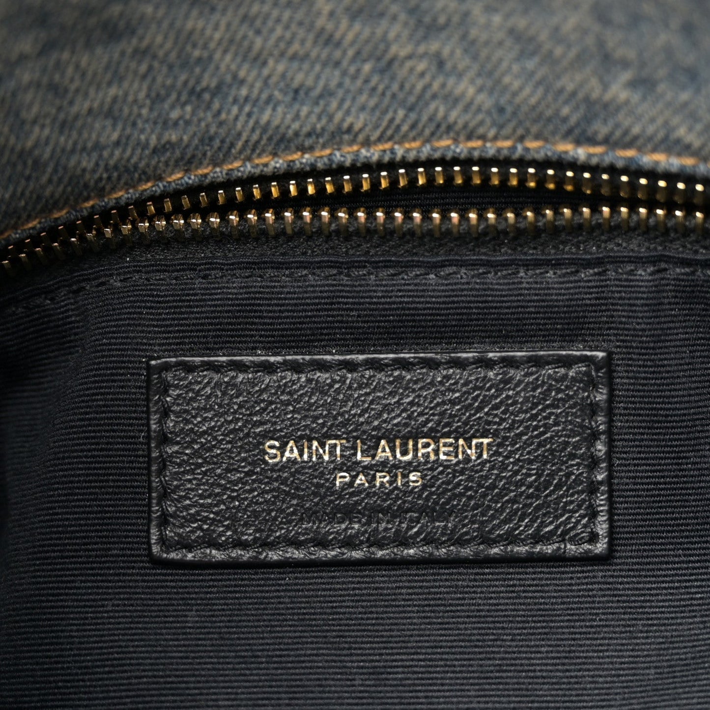 Denim satchel inner label with gold zipper and SAINT LAURENT PARIS branding
