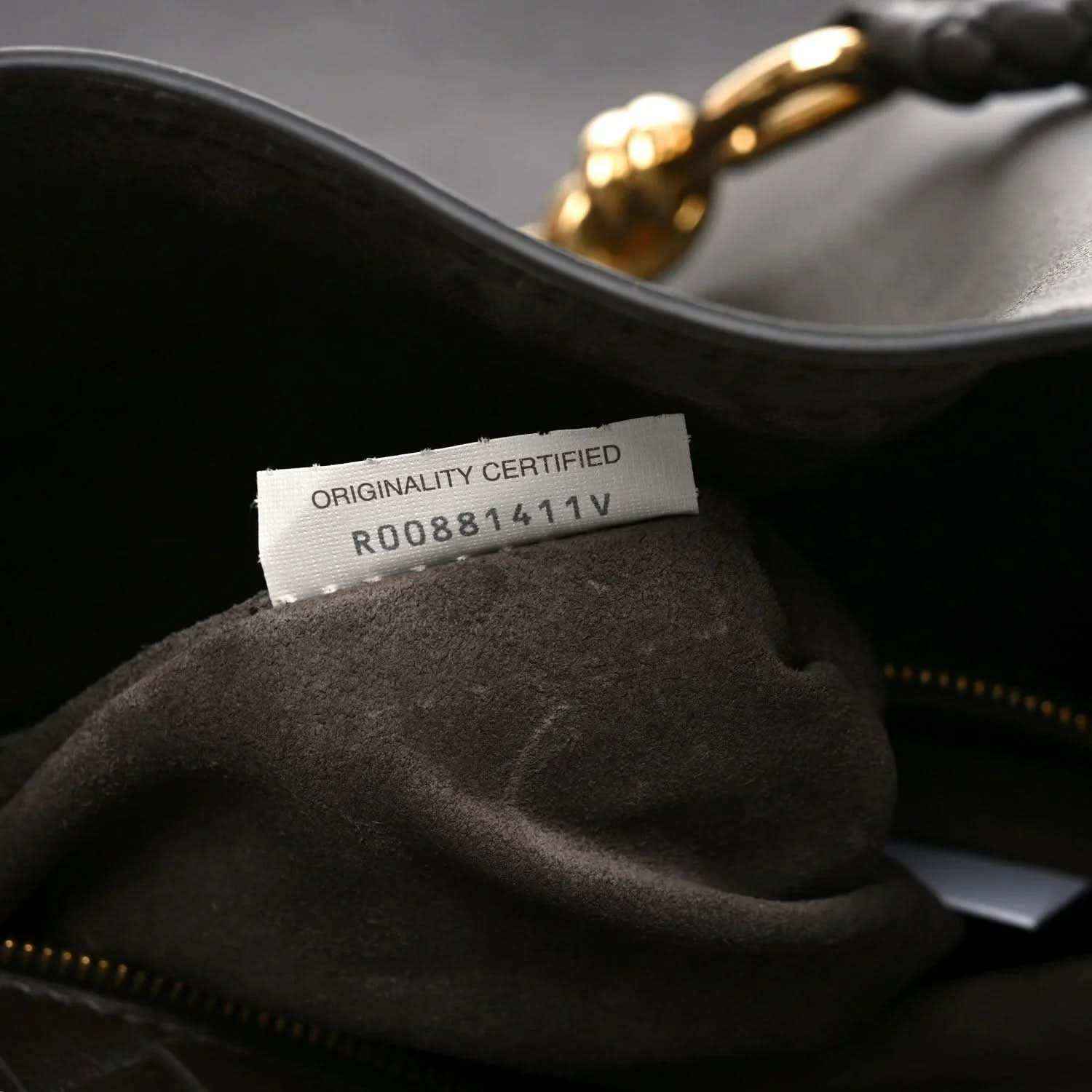 Small bucket bag interior with authenticity label and dark fabric lining