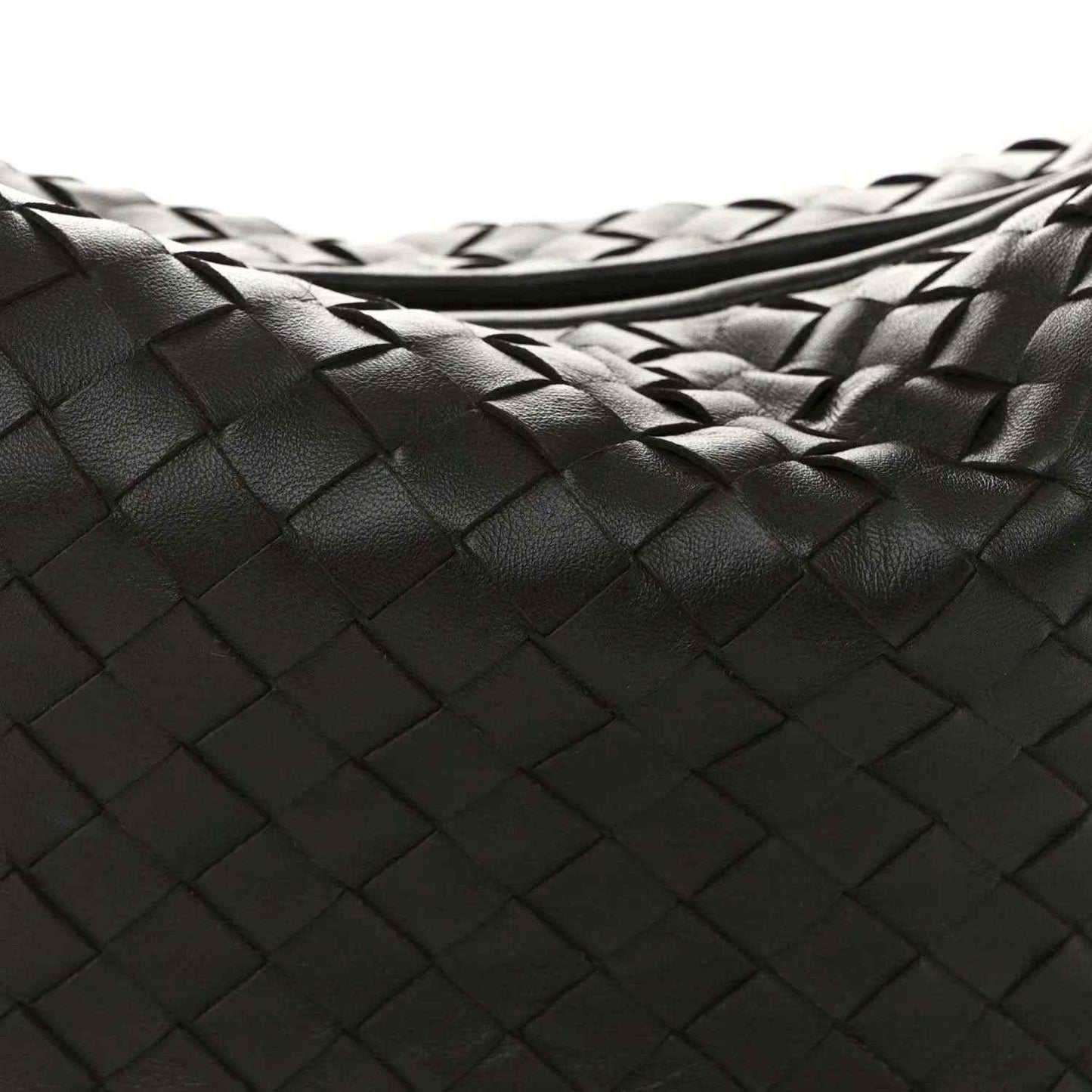 Close-up of woven leather intrecciato pattern on dark hobo bag