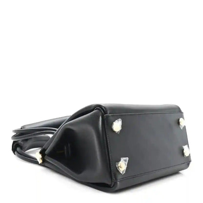 Small black leather handbag with side studs and top handles