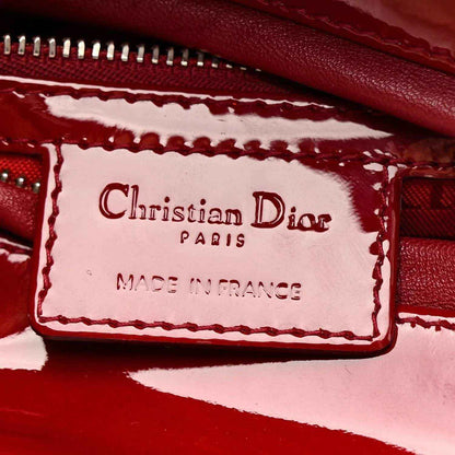 Christian Dior Paris Made in France label inside red handbag with stitched trim.