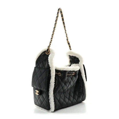 Black quilted shearling-trim handbag with gold chain shoulder strap and flap closure