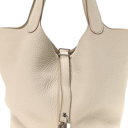 Ivory leather tote bag with top zipper and metal pull clasp