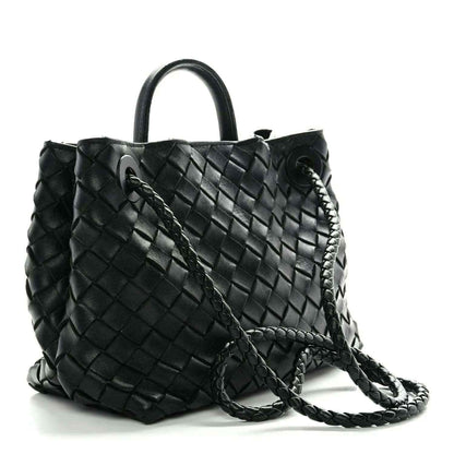 Black woven leather shoulder bag with braided crossbody strap and side tassels