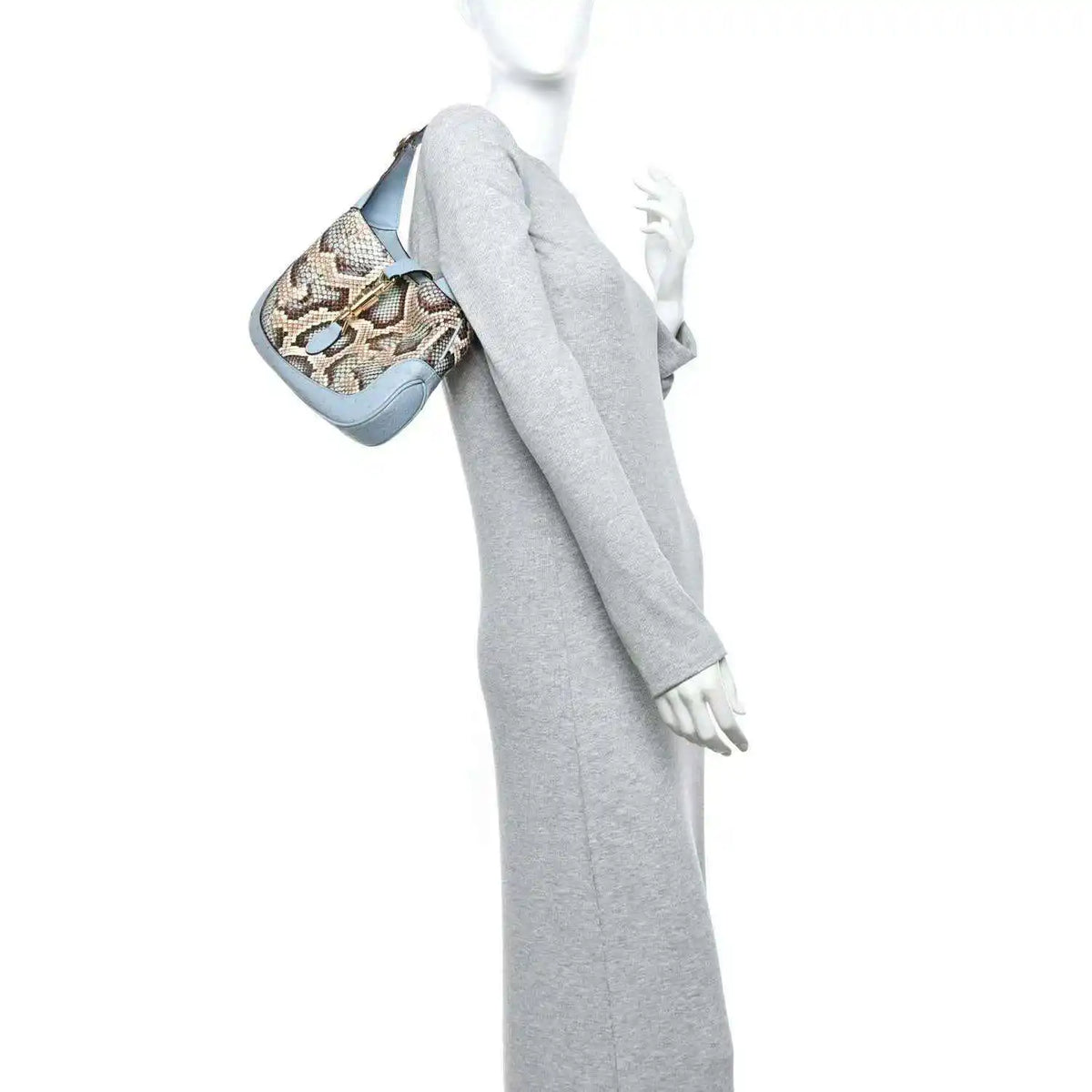 Small hobo bag held at side, featuring snakeskin print and light blue leather trim