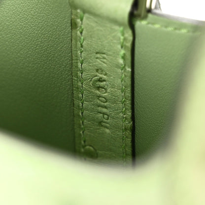Green ostrich-embossed leather handbag corner with vertical stitched detail