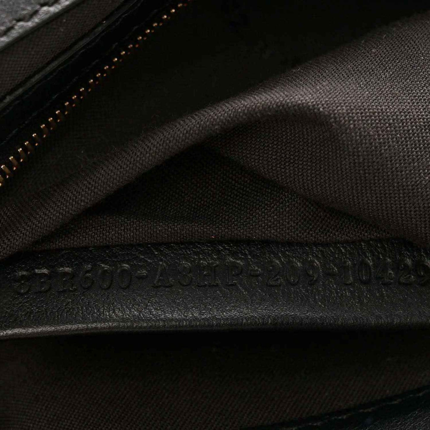 Dark interior fabric lining with stitched seam and zipper trim on the bag.