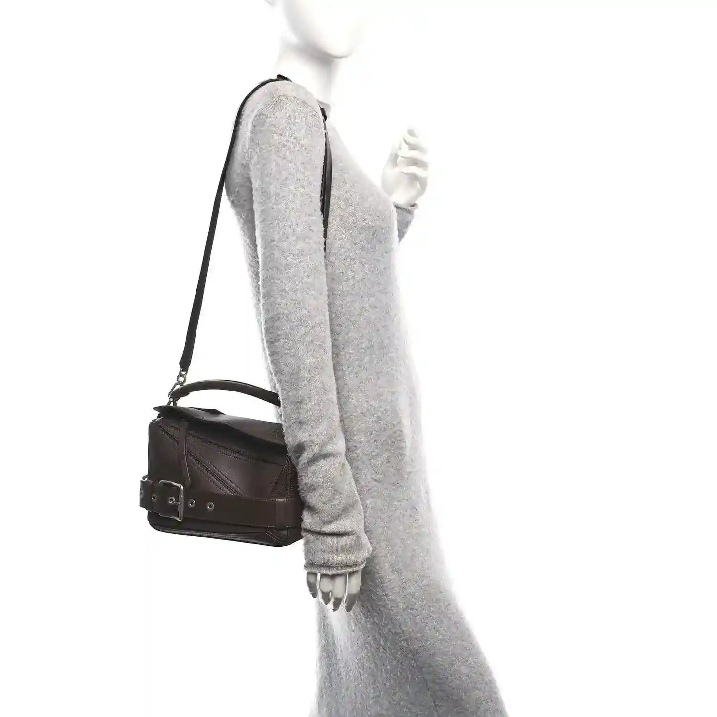Small leather biker bag on shoulder with dark brown strap and compact rectangular shape