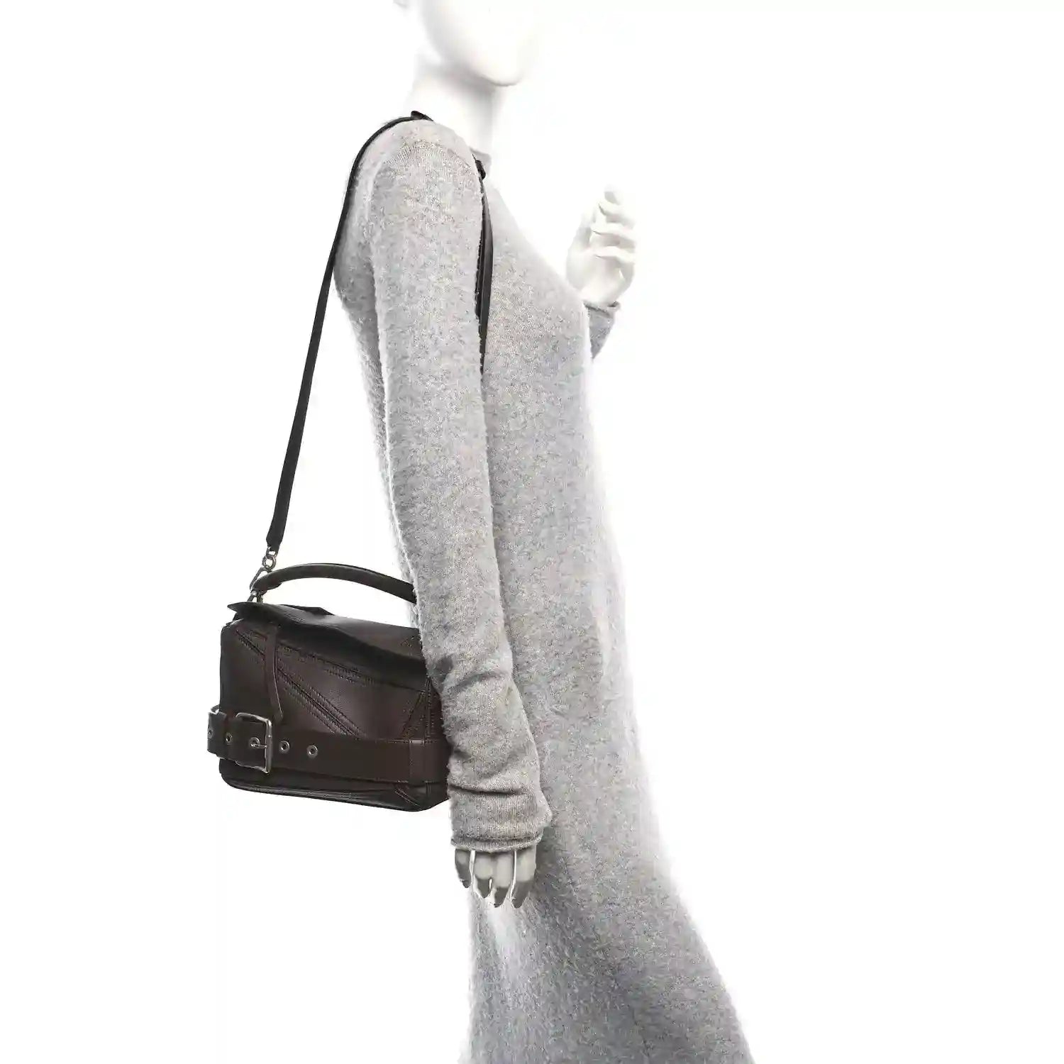 Small leather biker bag on shoulder with dark brown strap and compact rectangular shape