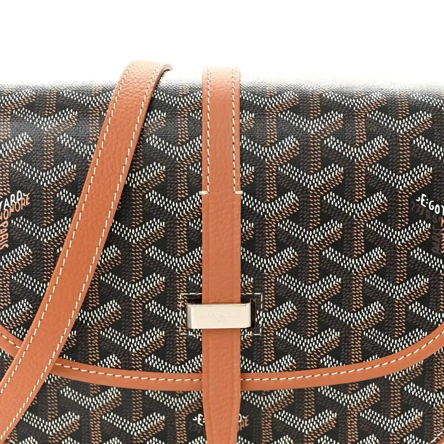 Front flap of monogram messenger bag with tan leather trim and metal logo bar
