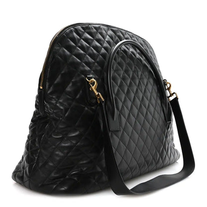 Black quilted leather travel bag with front zip pocket and adjustable shoulder strap