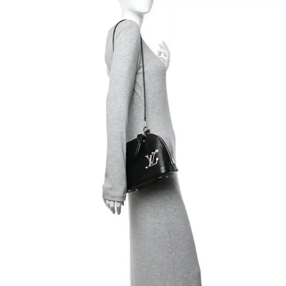 Black handbag on arm with top handle, gold zipper hardware, and colorful LV motif