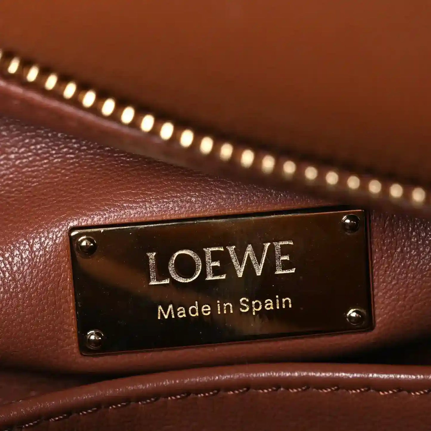 LOEWE leather bag plaque reading “LOEWE” and “Made in Spain”