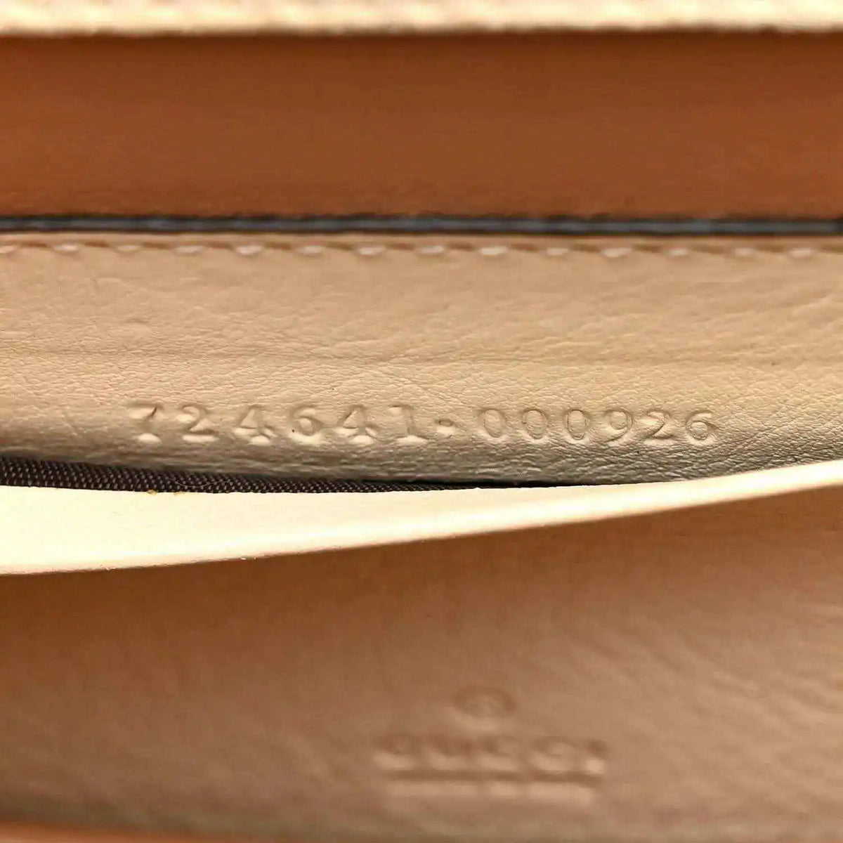 Stamped serial number on inside leather panel of a white mini handbag