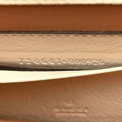 Stamped serial number on inside leather panel of a white mini handbag