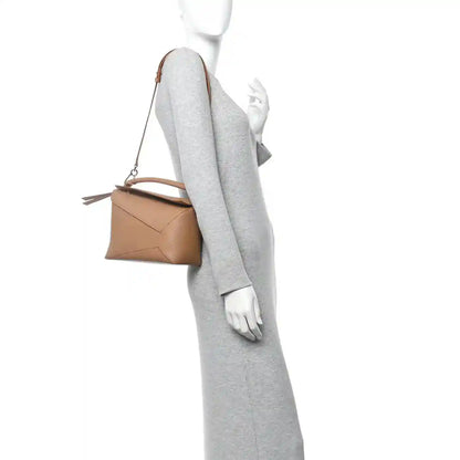 Toffee Puzzle Edge small bag with thin shoulder strap, shown at side on a model