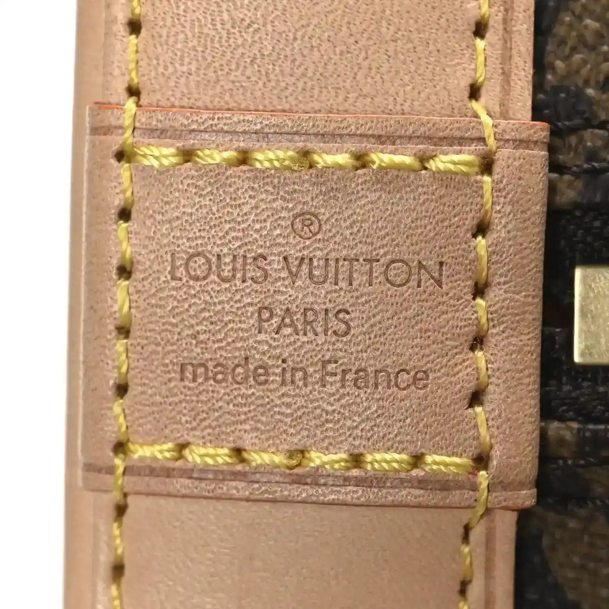 Leather handbag label reading 'Louis Vuitton Paris made in France' with yellow stitching.