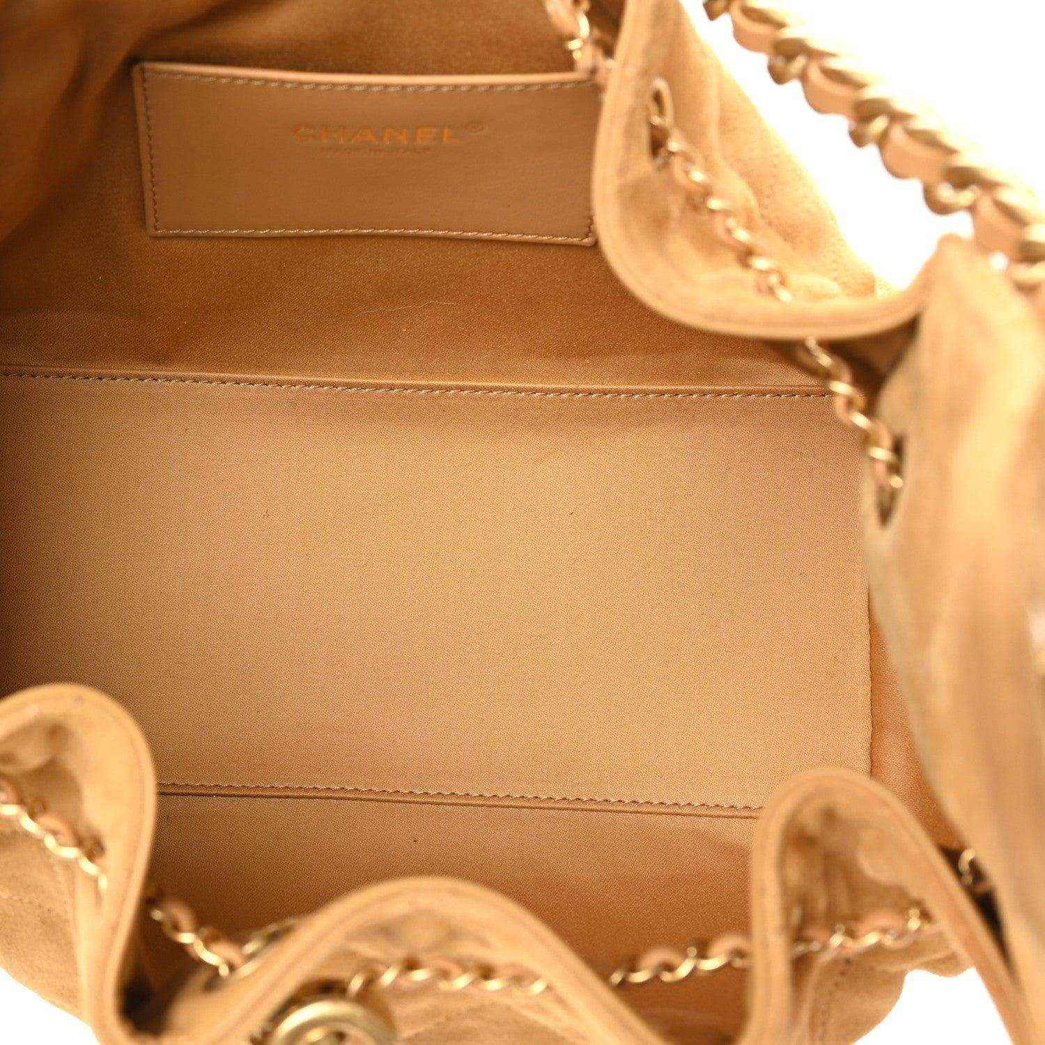 Chanel suede handbag interior with stitched edge and chain hardware close-up