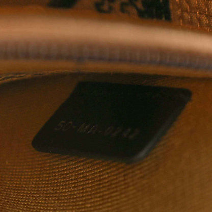 Dark leather interior patch inside jute canvas bag with stamped text.
