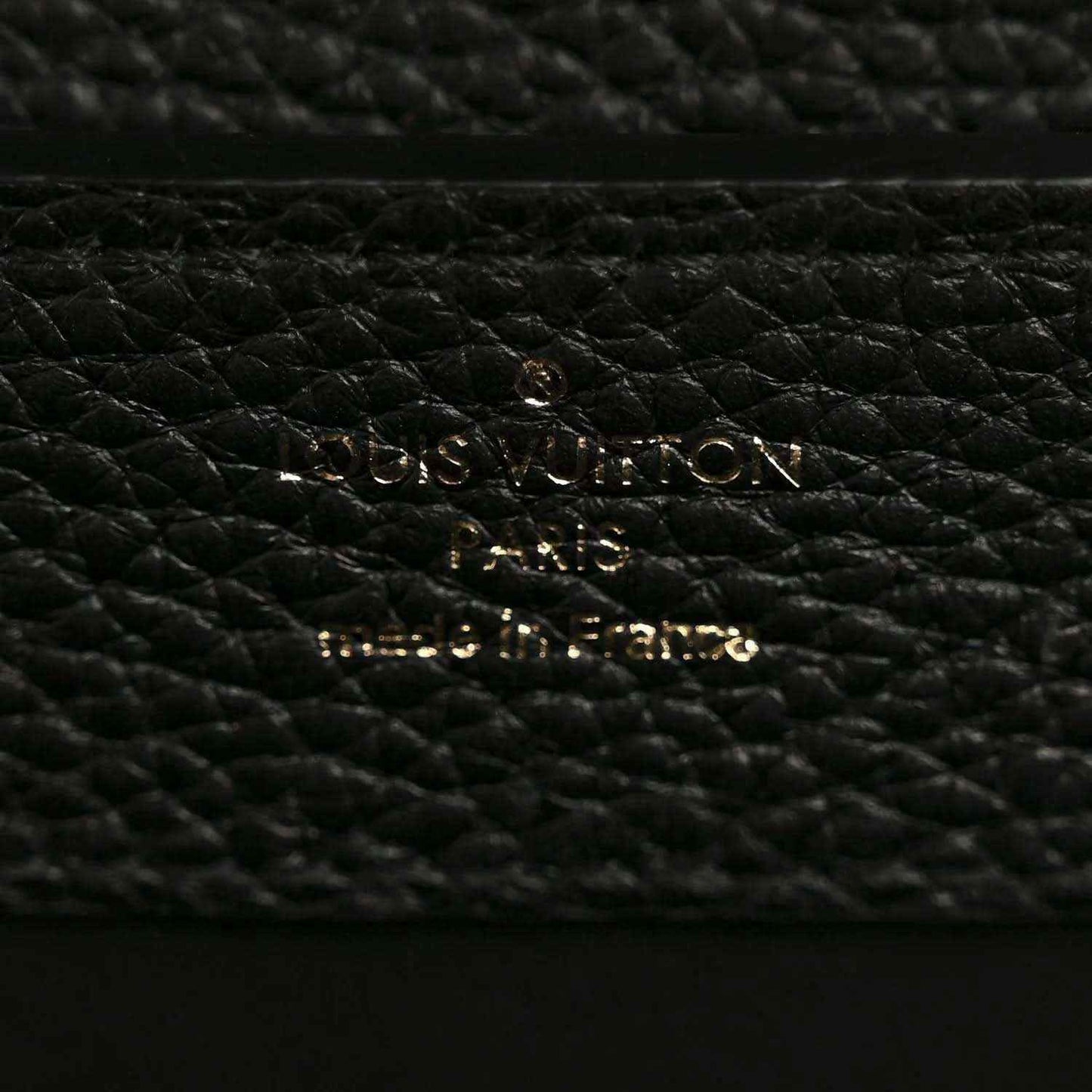 Black pebbled leather mini handbag close-up of gold hardware on lining