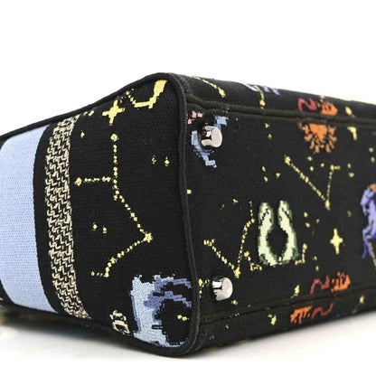 Black canvas handbag end panel with embroidered zodiac figures and two metal snap buttons