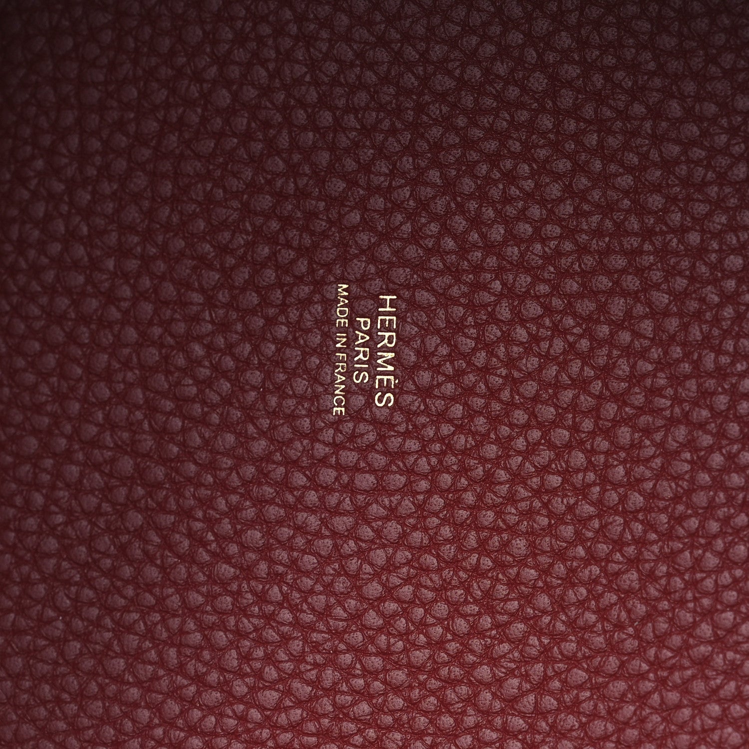 Burgundy grained leather panel with embossed brand text
