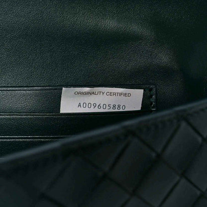 Emerald green clutch bag with Originality Certified tag and serial code