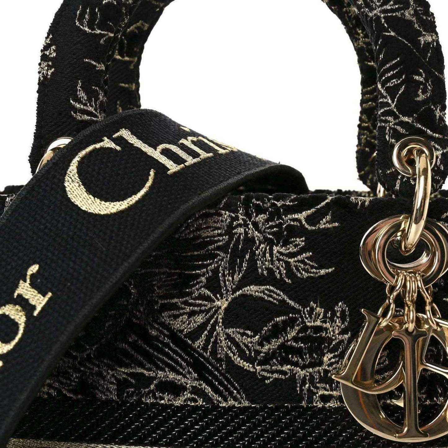 Close-up of black handle strap with gold embroidery and a gold ring charm