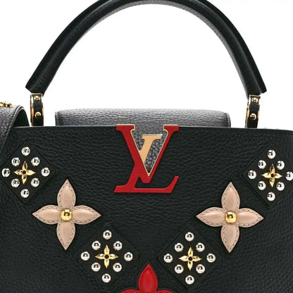 Black Louis Vuitton handbag front with red LV emblem and floral butterfly embellishments