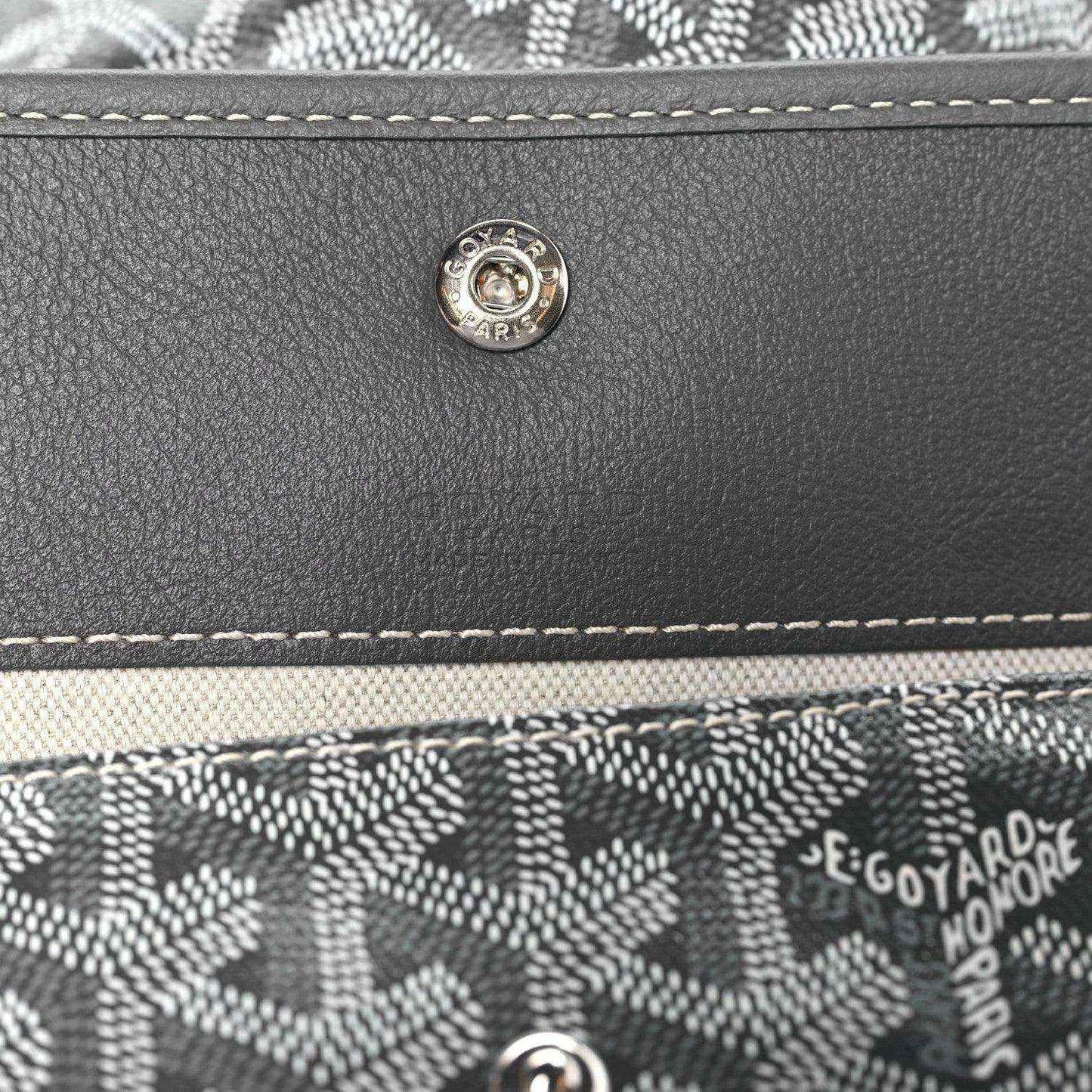 Front flap snap button and stitched trim on grey coated canvas hobo bag