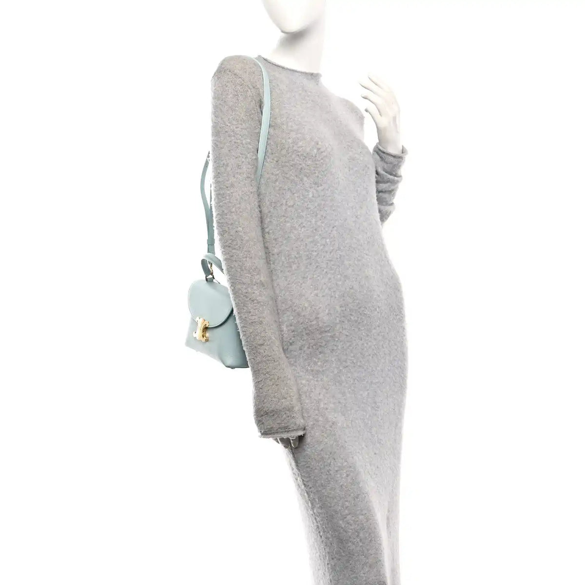 Light blue leather crossbody bag on mannequin with front flap and strap