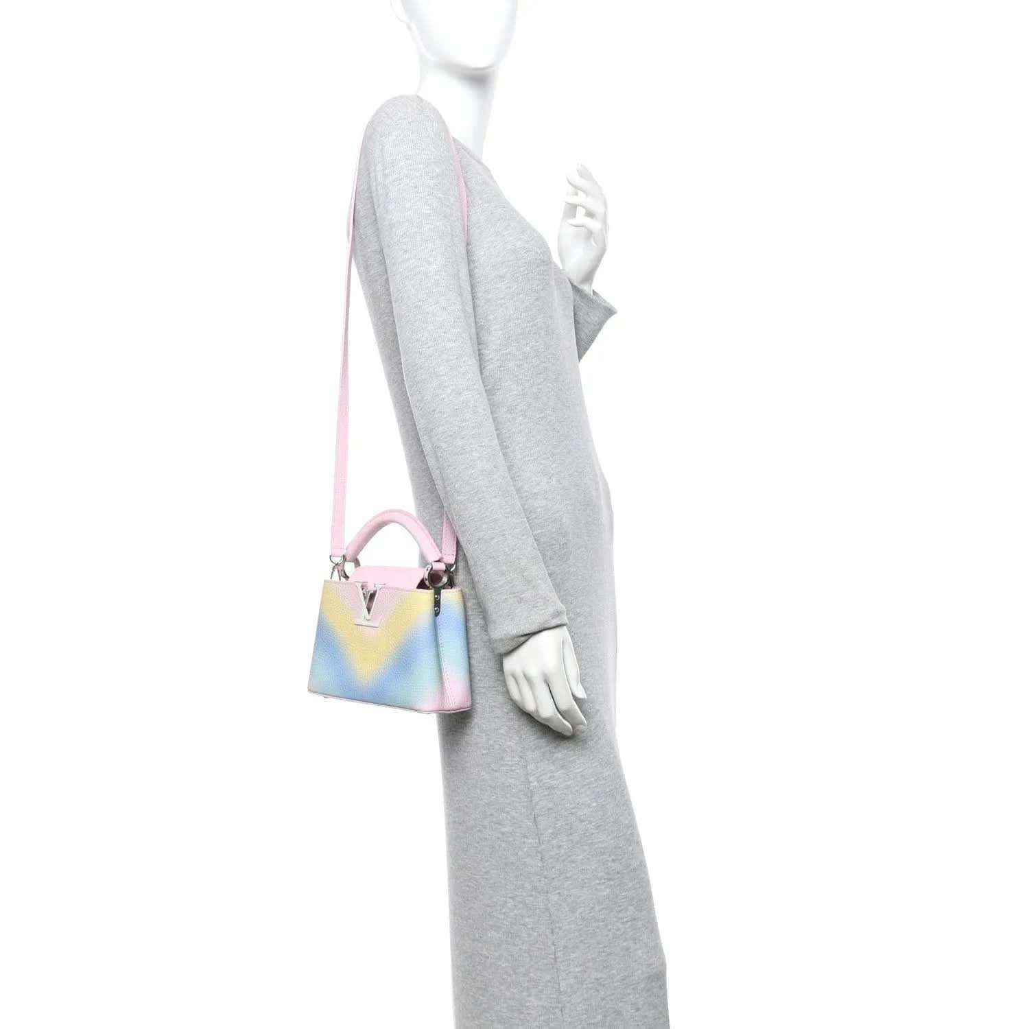 Mini Capucines bag worn crossbody, rainbow leather with pink strap and metal clasp