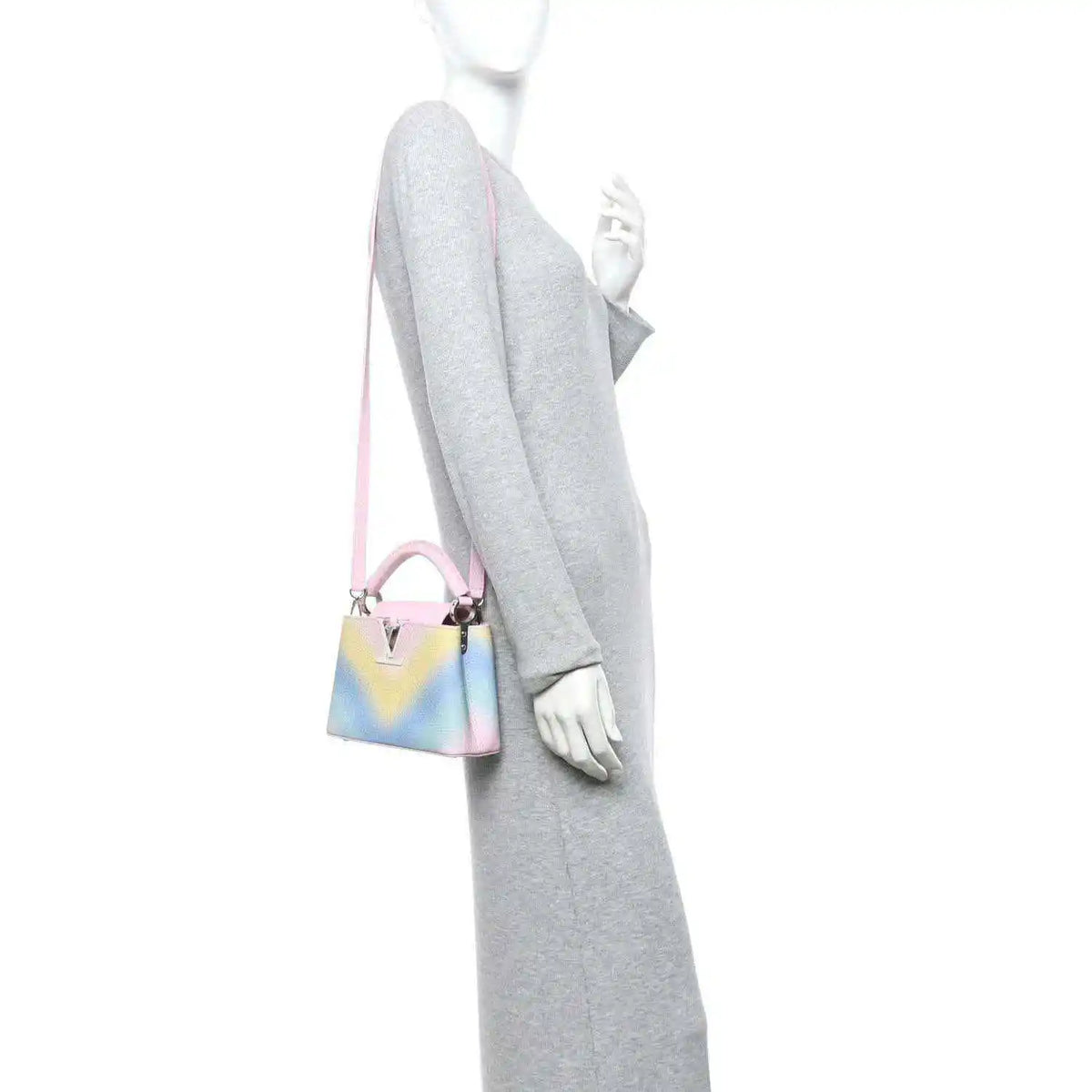 Mini Capucines bag worn crossbody, rainbow leather with pink strap and metal clasp
