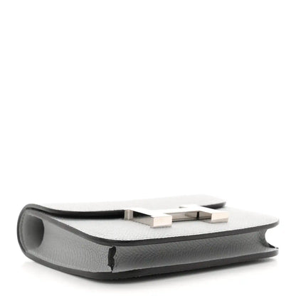 Hermes Constance slim wallet underside, light blue textured leather with stitched edge.