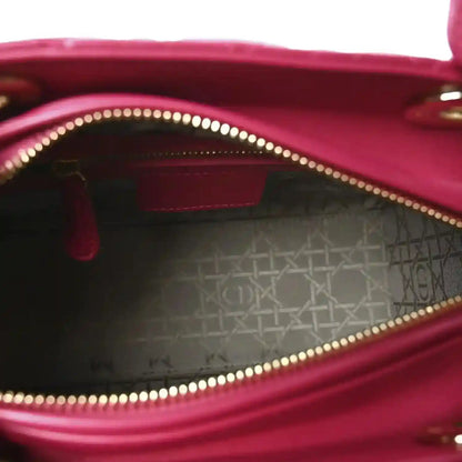 Fuchsia leather handbag interior with gold-tone zipper trim and stitched lining