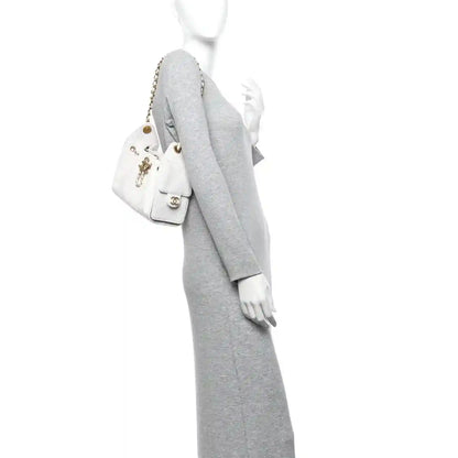 White quilted mini handbag with gold chain strap and front charm detail