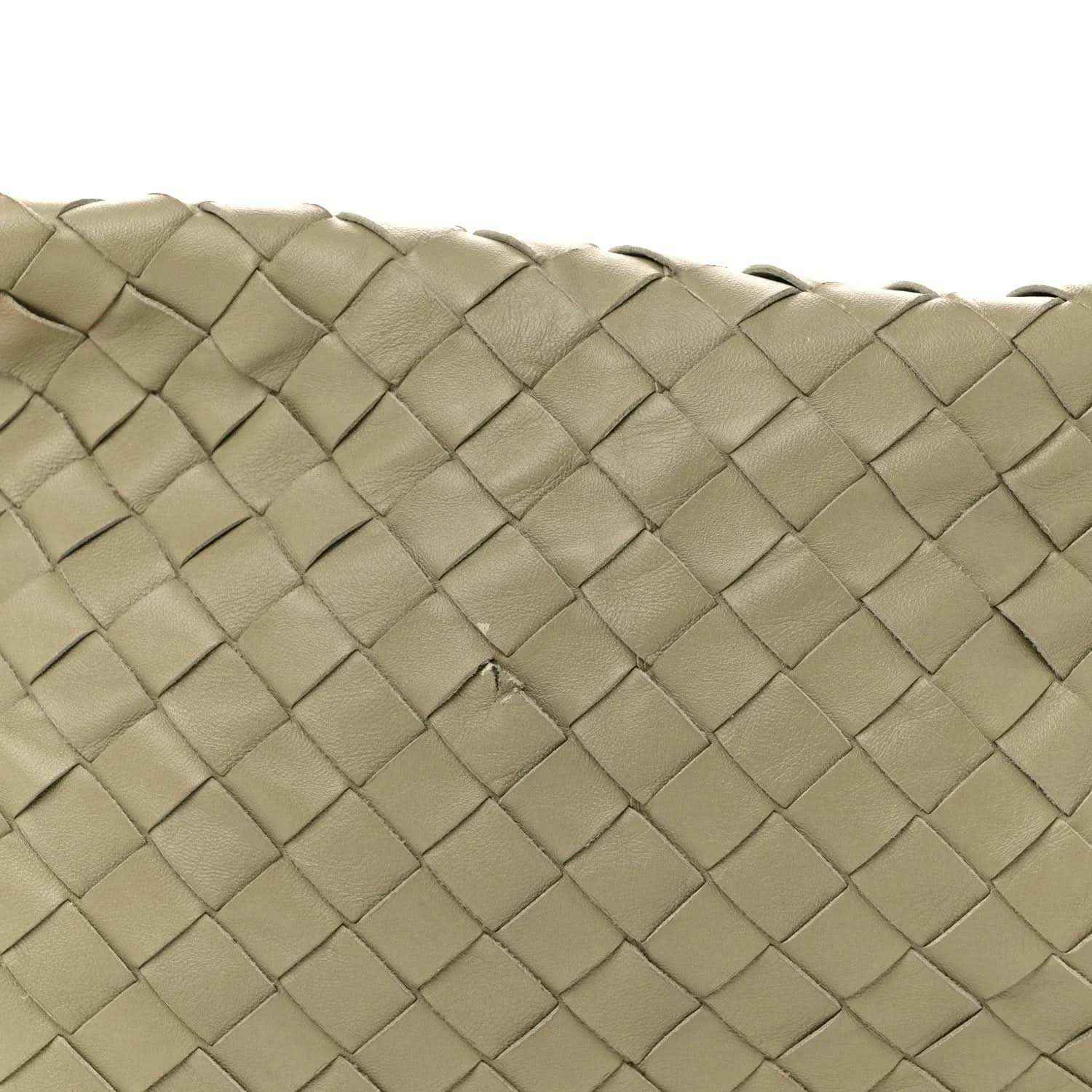 Close-up of woven lambskin leather texture on hobo bag exterior, travertine