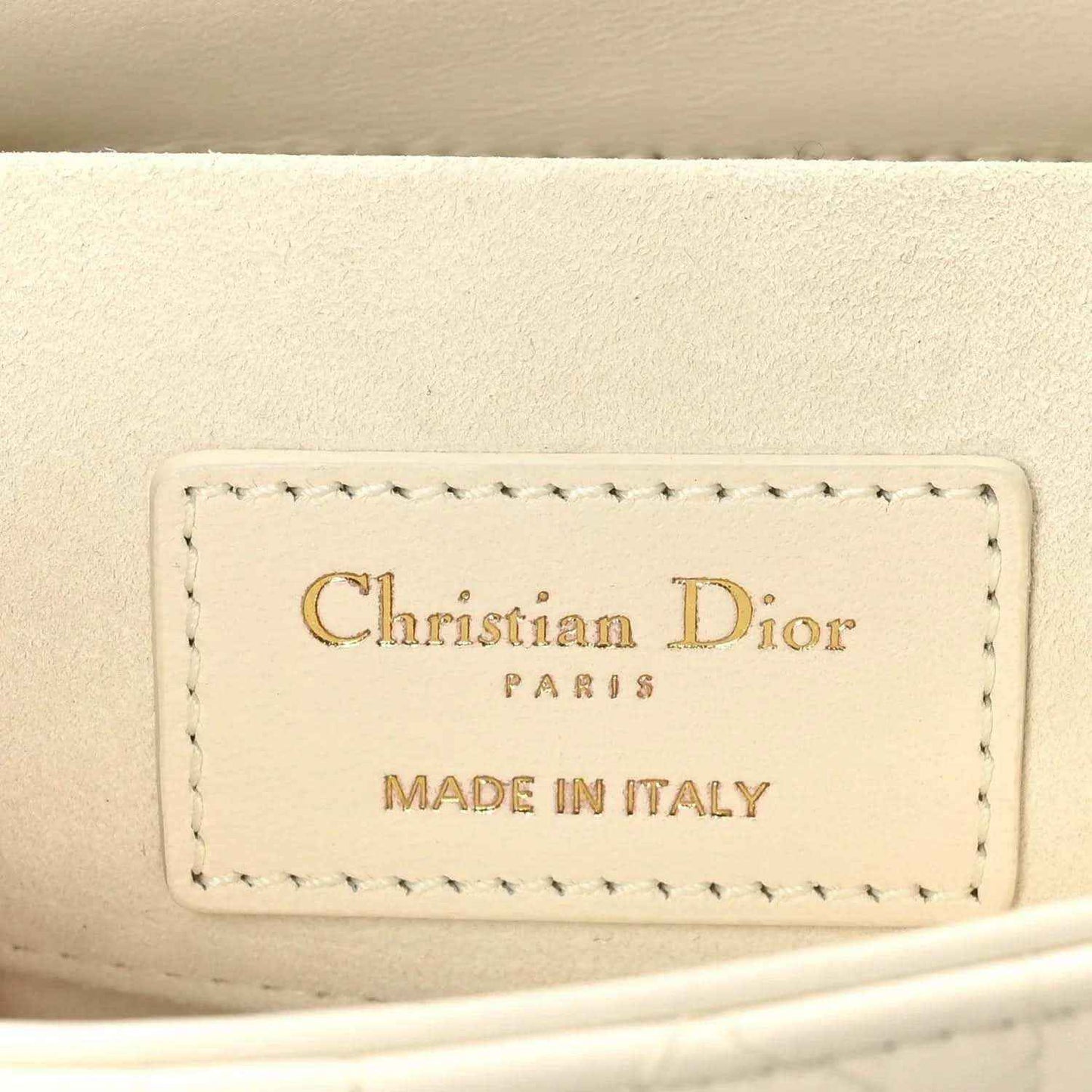 White handbag interior label reading Christian Dior Paris and Made in Italy