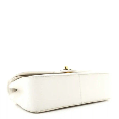 White leather mini bag side view with gold-tone hardware and top edge