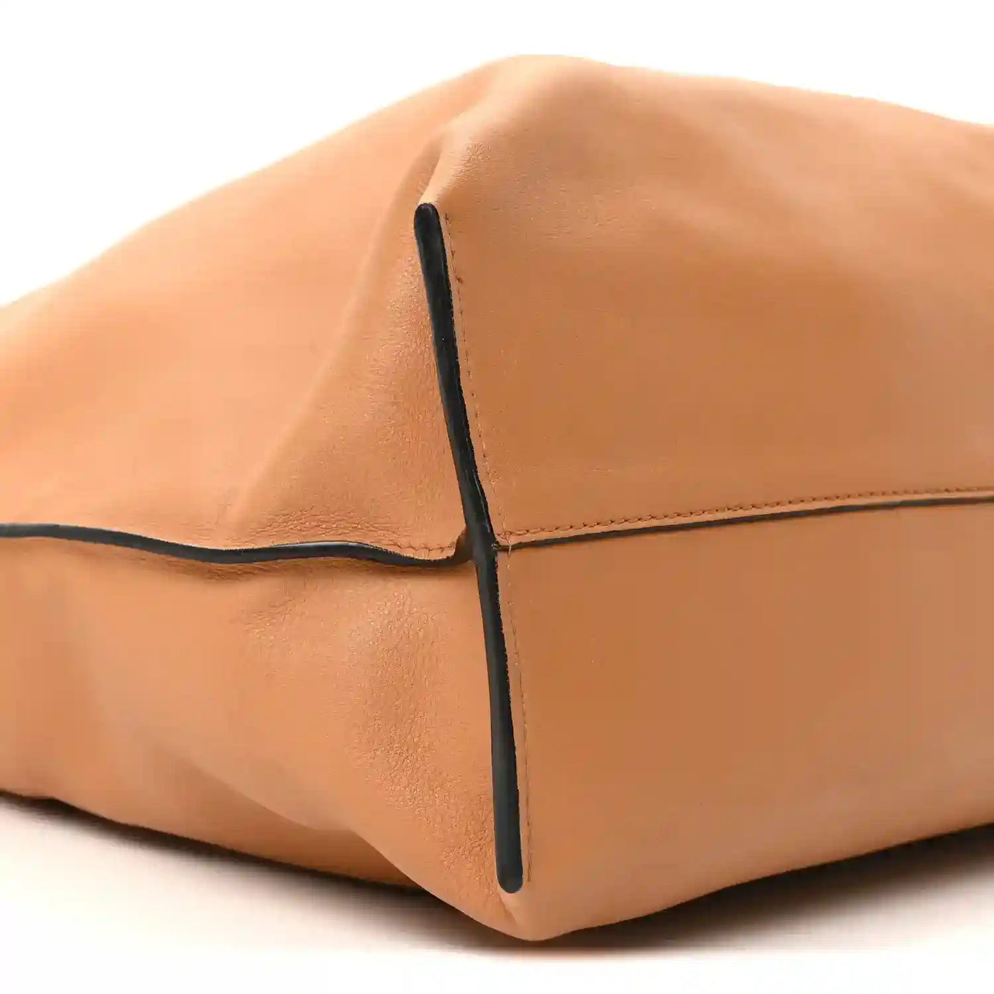 Loewe Flamenco knot bag corner close-up, warm tan leather with dark edge trim.